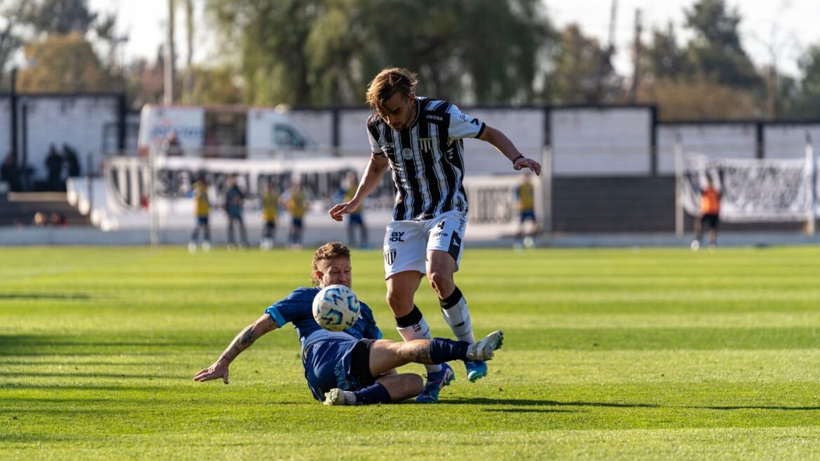 Exciting football tackle scene during a match on a sunny day in a professional stadium.